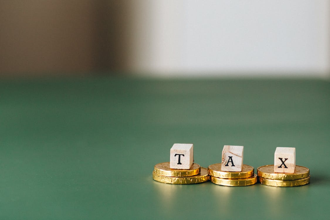 Tax word on top of coins