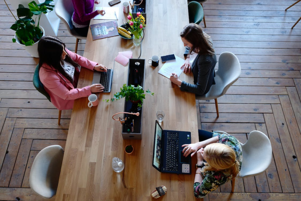 Three professionals using laptops in the office