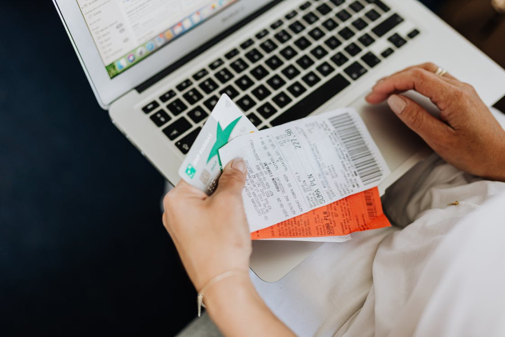 Person holding receipts and laptop