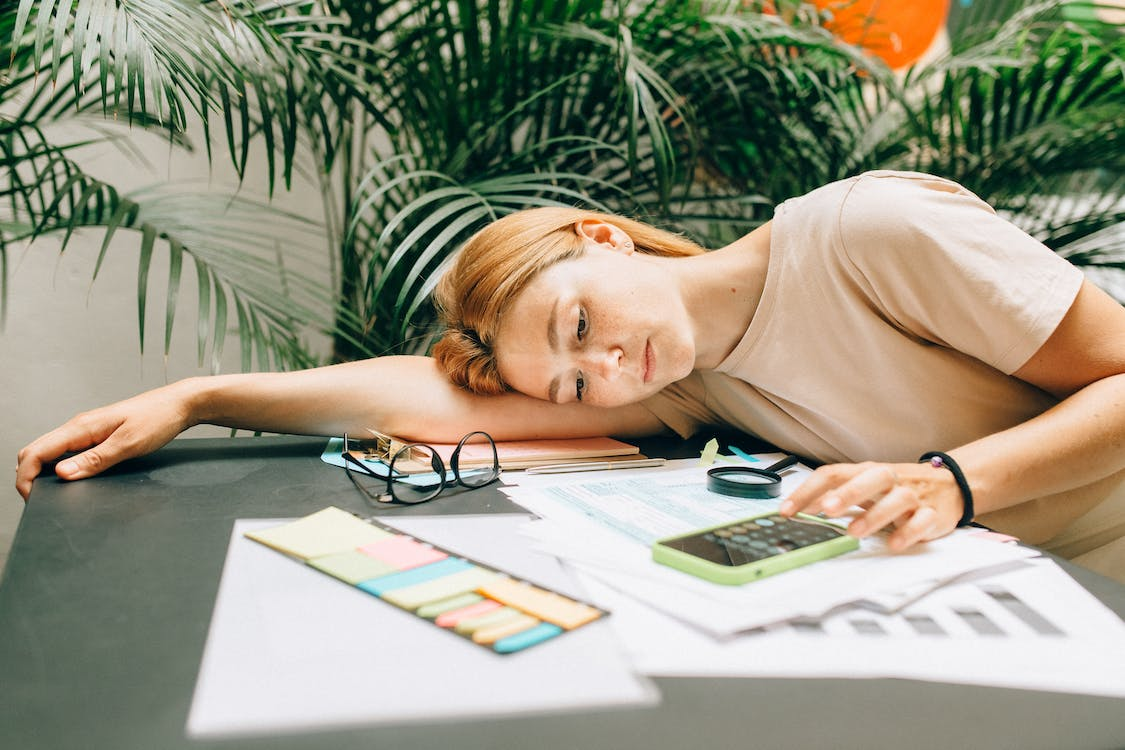 A tax professional resting head over tax documents