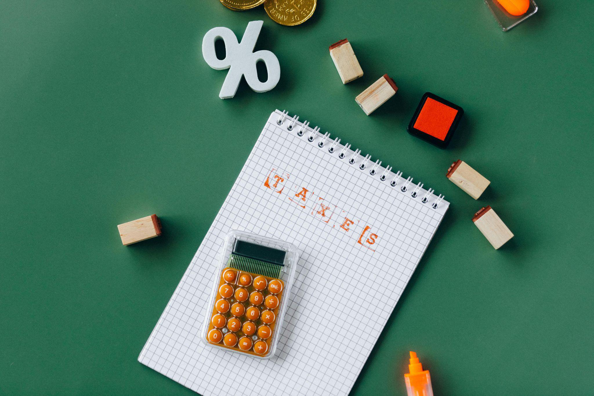 A notebook with TAXES in bold orange print