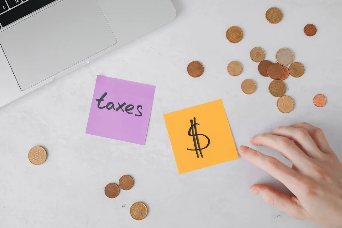 A purple and orange note with the words TAXES and a dollar sign