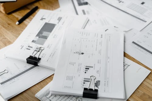 bunch of financial documents on a wooden surface