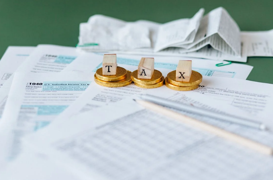 tax documents and a pencil lying on a green table with receipts in the background