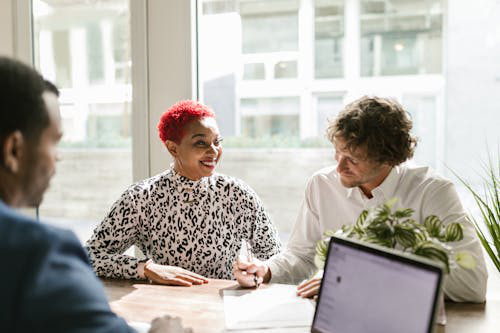 A couple reviewing tax documents with a professional accountant offering assistance.
