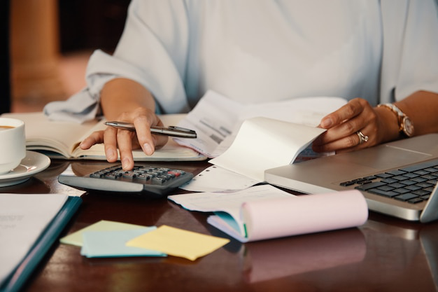 A person using a calculator to work on tax documents, emphasizing the importance of accurate tax planning and compliance.