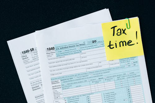 A stack of tax documents and financial statements for business tax filing.