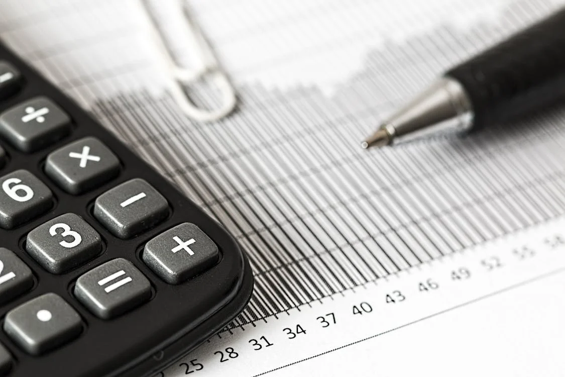 a pen and calculator on a sheet