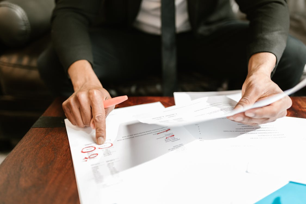 a person going through documents and using a red marker on them