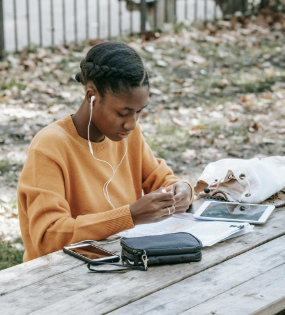 This image shows a girl using headphones to study notes from a smart phone.