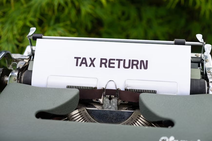 a typewriter with a tax return sign
