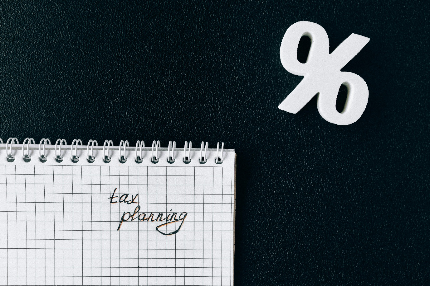 A photo showing a notepad and a symbol of a percent sign