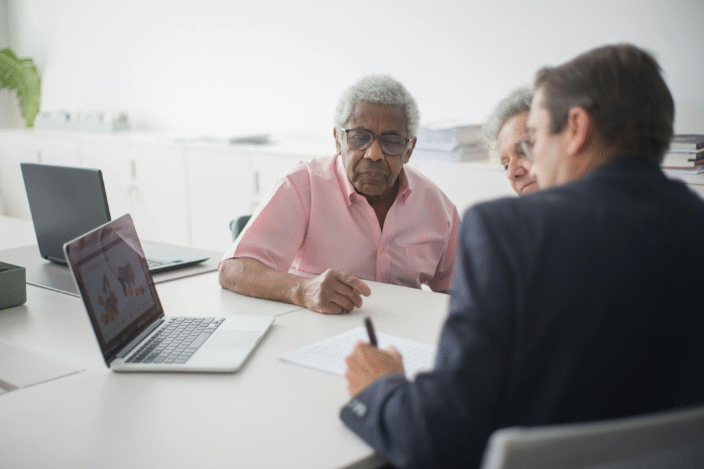 A photo showing two elderly people discussing something with a consultant