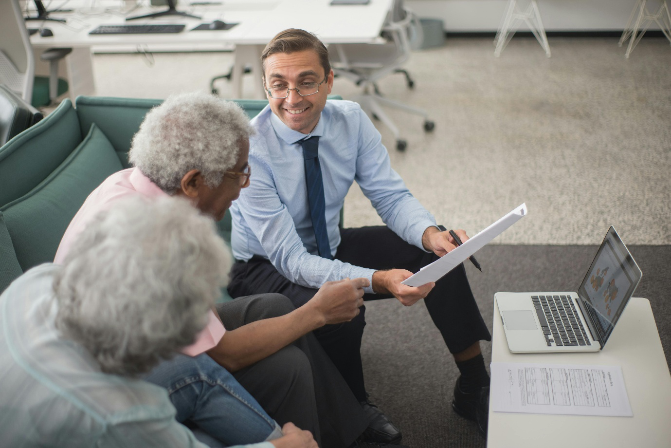 photo showing a person showing a document to two elderly people