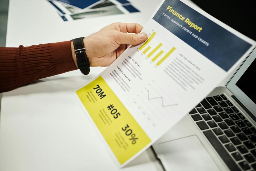Person analyzing finance report with graphs at desk, ideal for business concepts.