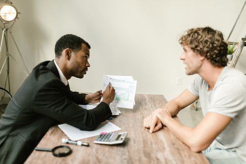 Financial professional discussing a printed report with a business owner